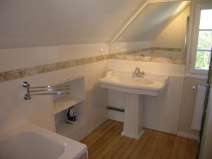 baño blanco con lavabo y ventana en Chalet de Vasterival, en Varengeville-sur-Mer