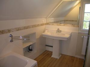 a white bathroom with a sink and a window at Chalet de Vasterival in Varengeville-sur-Mer