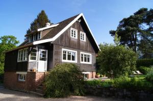 a house with a black roof and white windows at Chalet de Vasterival in Varengeville-sur-Mer