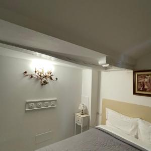 波代諾內的住宿－MANTICA CATTANEO APPARTAMENT，卧室配有一张床,墙上有灯