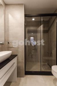 a bathroom with a glass shower and a sink at Delightful Apartment Near Shopping Del Sol in Asunción