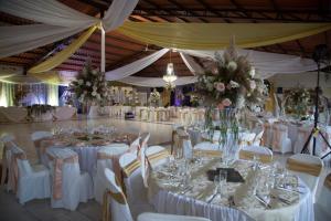 un salón de banquetes con mesas blancas y sillas blancas en Hosteria Hachacaspi en Puyo