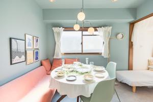 uma sala de jantar com uma mesa branca e um sofá em HARMONIA東京堀切502 em Tóquio