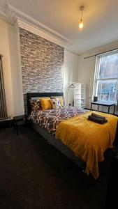 a bedroom with a bed and a brick wall at 10 Minutes to Central London Vaux in London