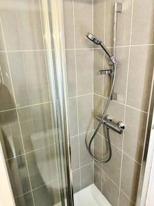 une douche avec une porte en verre à côté des toilettes dans l'établissement Bel appartement rénové dans une résidence calme, à Caen