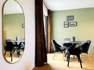 a mirror in a room with a table and chairs at Bel appartement rénové dans une résidence calme in Caen