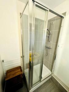 a shower with a glass door in a bathroom at Bel appartement rénové dans une résidence calme in Caen