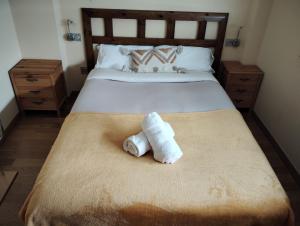 a bed with two rolled towels sitting on it at Apartamento Punta Balea in Cangas de Morrazo