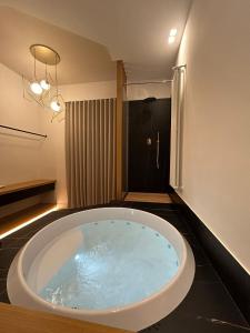 a large bath tub in a bathroom with a shower at Belladonna Luxury Apartment in Cava deʼ Tirreni