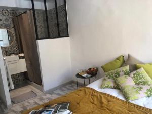 a bedroom with a bed with green pillows and a table at ÉcoHavre Correns in Correns