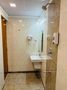 a bathroom with a sink and a shower at Greens Elite-Business Class Hotel Near Chennai Central Railway Station in Chennai +27 photos