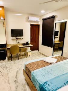 a hotel room with a bed and a desk at GREENS ELITE in Chennai