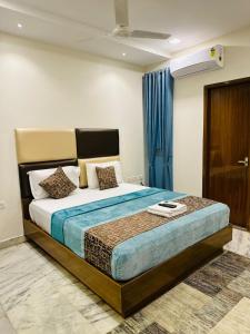 a bedroom with a large bed with blue curtains at GREENS ELITE in Chennai