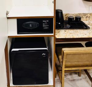 a kitchen with a black microwave in a cabinet at Greens Elite-Business Class Hotel Near Chennai Central Railway Station in Chennai