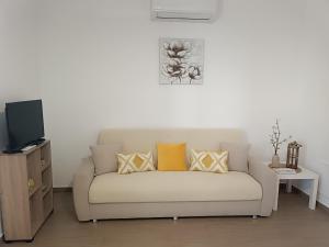 a couch with pillows on it in a living room at Appartamento turistico Olivella in Formia