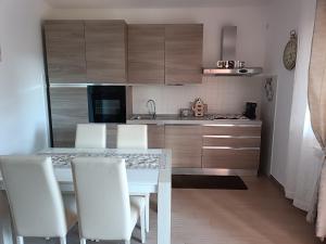 a kitchen with a white table and white chairs at Appartamento turistico Olivella in Formia