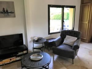 a living room with a chair and a television at Rose Marie in Varengeville-sur-Mer
