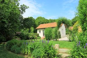 a cottage in a garden with purple flowers at Nid de Mer in Varengeville-sur-Mer