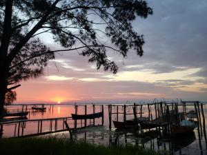 un coucher de soleil sur un lac avec des bateaux dans l'eau dans l'établissement Linda casa!, à Laguna