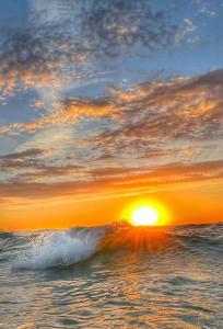 um pôr-do-sol sobre o oceano com uma onda em 5 Star Resort 6th fl 2BR 2 BATH King Suite Shuttle Pools, restaurants & more em Destin