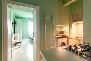uma cozinha com paredes verdes e um fogão forno superior em [Last Supper] Elegant Atelier em Milão