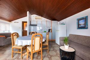 a kitchen and living room with a table and chairs at Apartments Antonija in Kampor