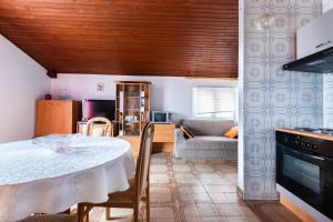a kitchen and living room with a table and a couch at Apartments Antonija in Kampor