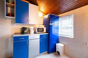 a kitchen with blue cabinets and a microwave at Apartments Antonija in Kampor +59 photos