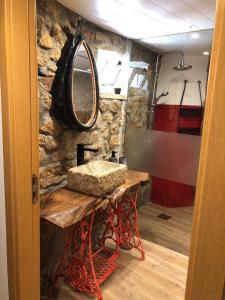 a bathroom with a sink and a stone wall at Casas do Lobo in Tarouca +20 photos
