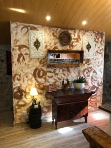 Habitación con pared de piedra y escritorio de madera. en Casas do Lobo, en Tarouca