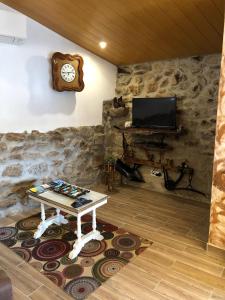 a living room with a table and a clock on the wall at Casas do Lobo in Tarouca