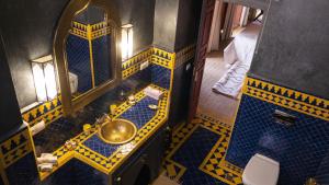 einen Blick über ein Bad mit einem Waschbecken und einem Spiegel in der Unterkunft Riad Afous in Marrakesch