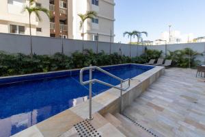 een zwembad aan de zijkant van een gebouw bij Apartamento 1106 em condomínio de alto padrão in Guarulhos