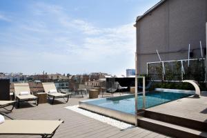 a rooftop patio with a swimming pool on a building at The Onsider - Luxury 3 Bedroom Apartment in Barcelona