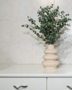 a white vase with a plant in it on a counter at Suites Campo de' Fiori - Zen Real Estate in Rome