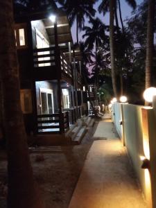 uma vista nocturna de um edifício com palmeiras e luzes em The Cool Huts em Mandrem
