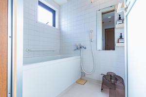 uma casa de banho branca com uma banheira e um lavatório em HARMONIA東京堀切502 em Tóquio