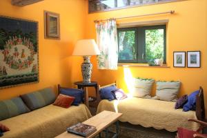 een woonkamer met twee bedden en een bank bij Ecuries de Coqueretaumont in Varengeville-sur-Mer