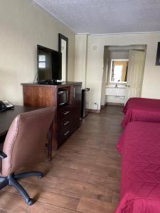 a hotel room with a desk and a bed and a television at Driftwood Inn - Lake City in Lake City +7 photos