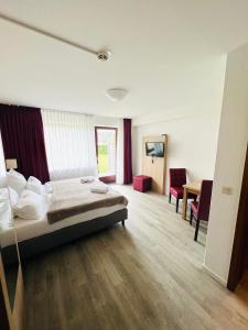 a hotel room with a bed and a table and chairs at Schröders Gästehaus in Langstedt