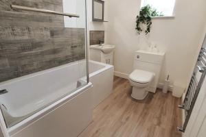 a bathroom with a toilet and a tub and a sink at Charming 2BD tranquil stay in Ferryhill, Durham in Ferryhill