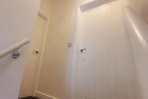 białe drzwi w pokoju ze schodami w obiekcie Charming 2BD tranquil stay in Ferryhill, Durham w mieście Ferryhill