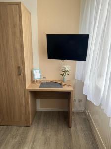 a desk with a computer monitor on top of it at Schröders Gästehaus in Langstedt