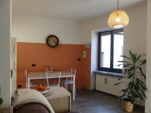sala de estar con mesa y reloj en la pared en L'alloggio in Piazza, en Robilante