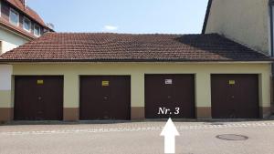 un edificio con cuatro puertas de garaje con el número mr en BOHO-Apartment, Feel like Home, Free Coffee, en Mühlacker
