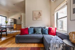 a living room with a gray couch with colorful pillows at East Village Townhouse in New York