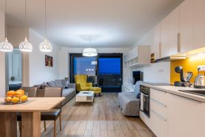 cocina y sala de estar con sofá y mesa en NFS - Národný futbalový štadión - Apartman en Bratislava