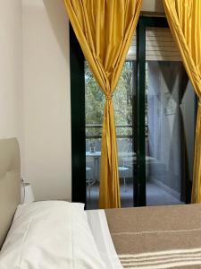 a bedroom with a bed and a window with yellow curtains at Home Station Perugia in Perugia