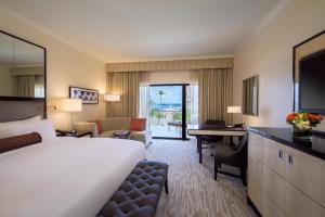 une chambre d'hôtel avec un lit et un salon dans l'établissement Hamilton Princess & Beach Club A Fairmont Managed Hotel, à Hamilton