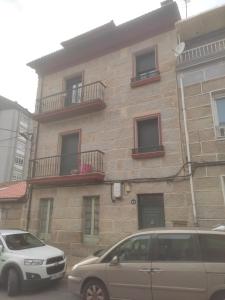 two cars parked in front of a brick building at Home Barbaña in Ourense